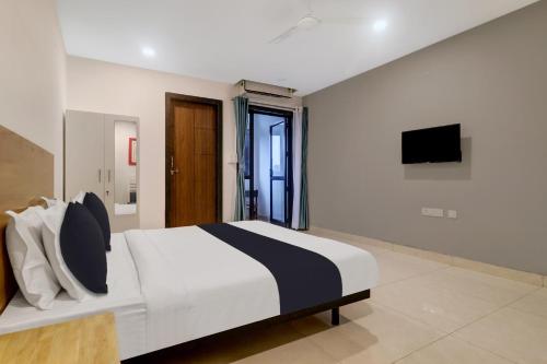 a bedroom with a large bed and a television at Townhouse OAK De Alphabet Hotel Bolarum in Hyderabad