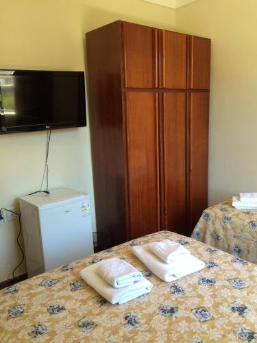 a hotel room with two towels on a bed at Casa da Ponte Hotel in Goiás