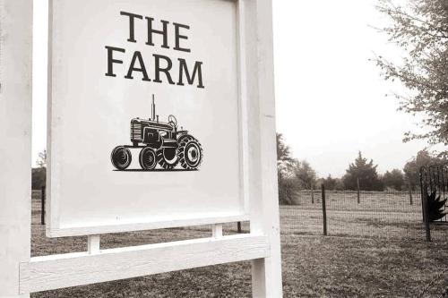 Una señal para una granja con un tractor. en Beautiful Farmhouse w/ pool on 6 acres ranch, en Aubrey
