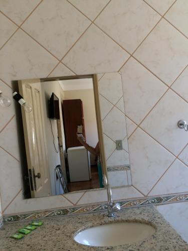 a person taking a picture in a bathroom mirror at Casa da Ponte Hotel in Goiás