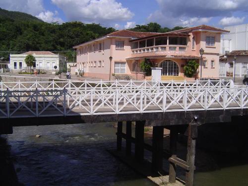 a white bridge over a river with a building at Casa da Ponte Hotel in Goiás