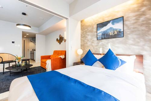 Una habitación de hotel con una cama y una sala de estar. en FDS AURA, en Osaka
