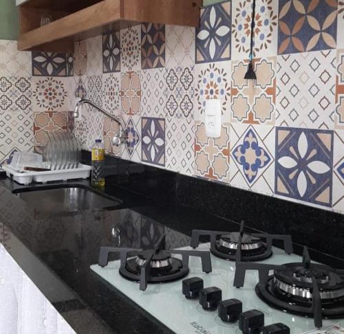 Casa da Pedra في Aracê: طاولة مطبخ مع موقد علوي مع بلاط