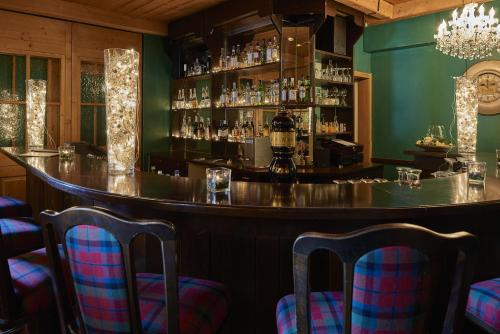 a bar with blue chairs and a green wall at Hostellerie am Schwarzsee in Bad-Schwarzsee