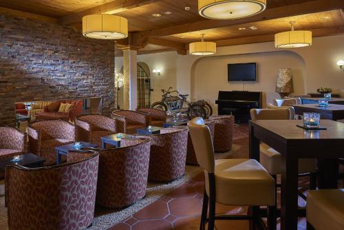 a restaurant with tables and chairs and a piano at Hostellerie am Schwarzsee in Bad-Schwarzsee