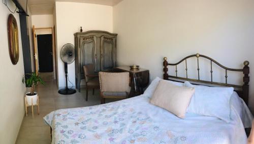 1 dormitorio con cama, silla y escritorio en Brisa en San Antonio de Areco