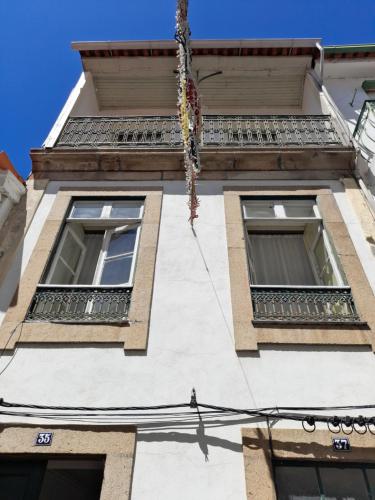 a tall white building with windows and balconies at Ninho do Corvo in Torre de Moncorvo