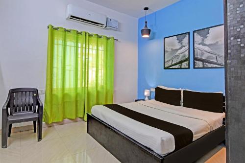 1 dormitorio con 1 cama con cortina verde y silla en Hotel O MOHAPATRA GUEST HOUSE, en Khandagiri