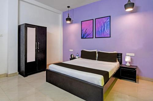 Un dormitorio con una cama grande con paredes moradas. en Hotel O MOHAPATRA GUEST HOUSE, en Khandagiri