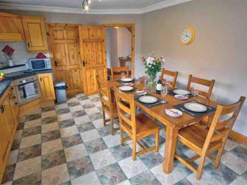 una cucina e una sala da pranzo con tavolo e sedie in legno di Mountain View House a Killarney