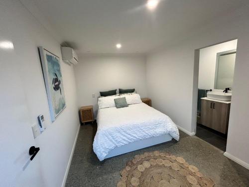 - une chambre avec un lit blanc et un lavabo dans l'établissement 17 Cooyou Close, à Exmouth