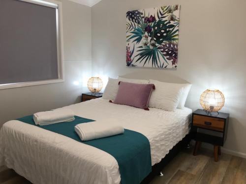 a bedroom with a bed with two lamps on it at Longreach Private Apartments in Longreach