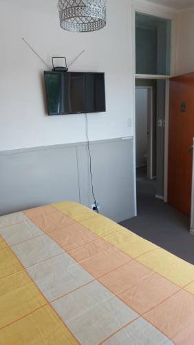 a room with a bed with a television on the wall at Bed and Breakfast Happy Home Taupo Accommodation in Taupo