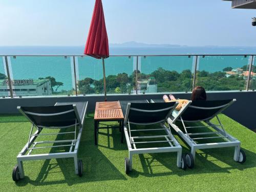 two chairs and a table on a roof at Pratamnak Pattaya Luxury Condo, Golf, Ocean View in Pattaya South