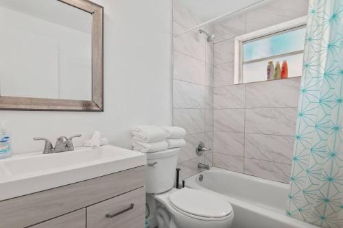 uma casa de banho com um lavatório, um WC e um espelho. em Balcony Chic Apt, w/2 Queenbeds, on Ocean Dr Beach em Miami Beach