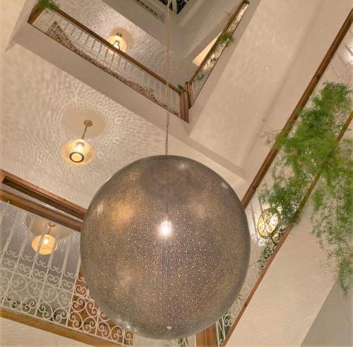 a large silver orb hanging from the ceiling of a building at Riad with 3 Swimming Pools in Marrakesh