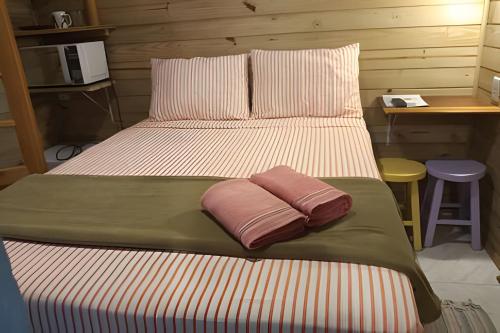 a bed with two pillows on it in a room at Pouso do Guarani - 200m do mar|wifi|Ar cond in Florianópolis