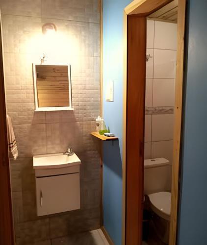 a small bathroom with a sink and a toilet at Pouso do Guarani - 200m do mar|wifi|Ar cond in Florianópolis