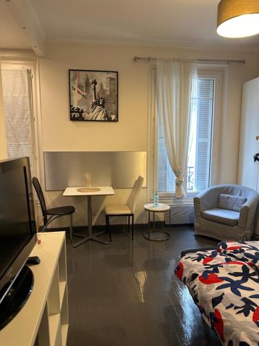 a living room with a bed a table and a couch at Chic studio near chatelet les halles in Paris