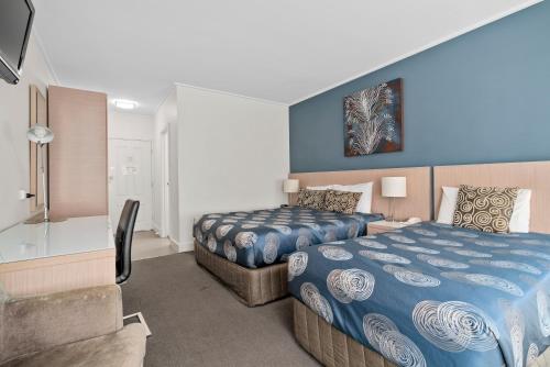 a hotel room with two beds and a window at Sherbourne Terrace Hotel in Shepparton