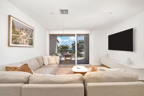 a living room with a couch and a tv at Blanca Beach House 2 Vincentia in Vincentia