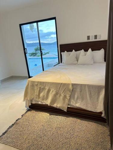 a bedroom with a bed with a view of the ocean at Villa Sunrise RD in Las Galeras