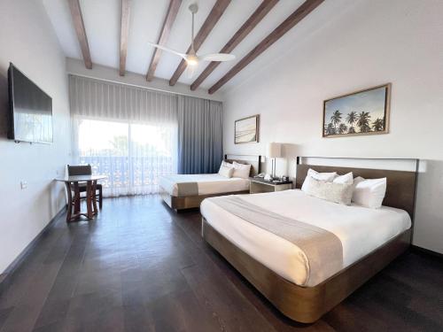 a hotel room with two beds and a window at San Nicolas Hotel Casino in Ensenada