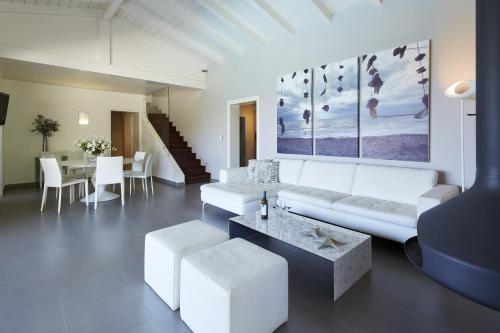 a living room with a white couch and a table at Villa Tatiana in Ágios Stéfanos