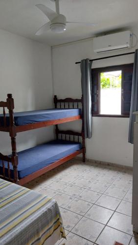 a room with two bunk beds and a window at Maury Chalés Boiçucanga in São Sebastião