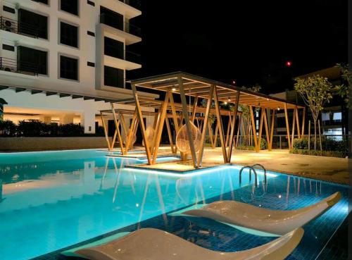 a swimming pool at night with a building in the background at K AVENUE FAMILY ROOM B09 in Donggongon