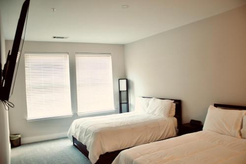 a bedroom with two beds and two windows at Upscale Luxury Fully loaded Equipped Loft in Atlanta
