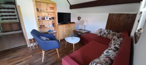 a living room with a red couch and a blue chair at Ubytovani Eden in Dlouhá Ves