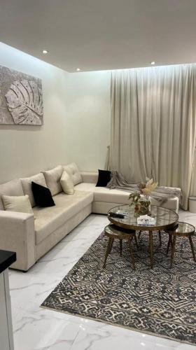a living room with a couch and a table at غرفة صالة هادئة أنيقة in Riyadh