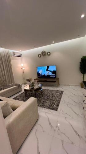 a living room with a couch and a flat screen tv at غرفة صالة هادئة أنيقة in Riyadh