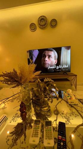 a table with several remote controls on a television at غرفة صالة هادئة أنيقة in Riyadh