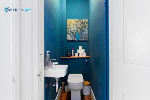 ein blaues Badezimmer mit WC und Waschbecken in der Unterkunft Tranquil 2 bed apartment Edinburgh in Edinburgh