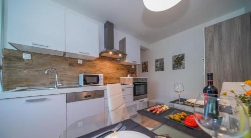 a kitchen with white cabinets and a table with fruit on it at Apartments with WiFi Varazdin, Zagorje - 22171 in Varaždin