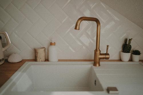 a sink with a faucet in a kitchen at Ti Studio Bohème, avec citerne in Le Gosier