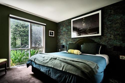 a bedroom with a large bed and a large window at Boatshed Villa Green Door in Daylesford