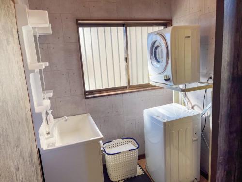 a bathroom with a sink and a washing machine at 【MeTeL】窓辺から壮大な富士が拝める。リノベーション済み一等貸し宿泊施設 in Nishikatsuracho