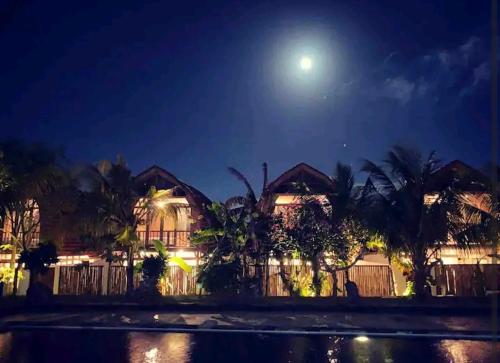 a house at night with the moon in the sky at Puri Jineng Uluwatu 4 in Uluwatu