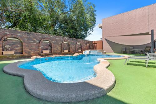 a swimming pool in a yard next to a building at Sherbourne Terrace Hotel in Shepparton