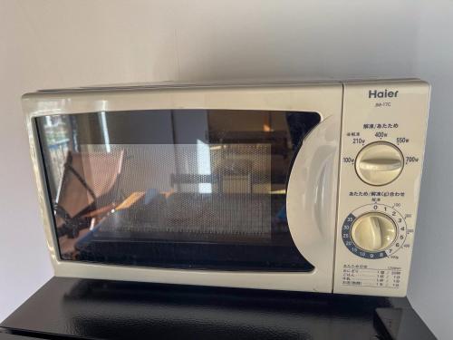 a microwave oven sitting on top of a table at 【MeTeL】窓辺から壮大な富士が拝める。リノベーション済み一等貸し宿泊施設 in Nishikatsuracho