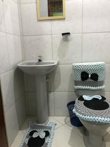 uma casa de banho com um lavatório e um WC com laços. em Vila Janaína em Canoa Quebrada