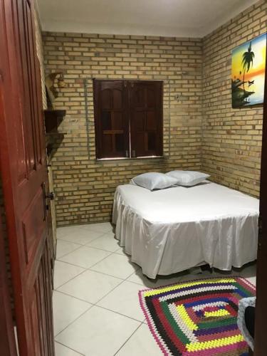 um quarto com uma cama branca e uma janela em Vila Janaína em Canoa Quebrada