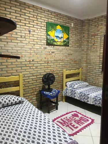 um quarto com duas camas e uma foto na parede em Vila Janaína em Canoa Quebrada