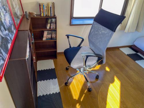 a office chair in a room with a book shelf at 【MeTeL】窓辺から壮大な富士が拝める。リノベーション済み一等貸し宿泊施設 in Nishikatsuracho