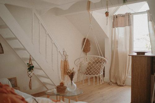 a room with a staircase with a chair and a table at Ti Studio Bohème, avec citerne in Le Gosier