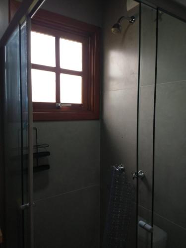 a bathroom with a shower and a window at Refúgio Verde - Cabana Quero-Quero in Nova Petrópolis