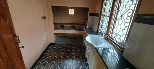 een kleine badkamer met een wastafel en een spiegel bij Karainagar Holiday Home 